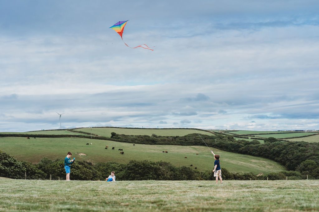 Children flying kites over the Cornish hills at Woodlands Manor Farm