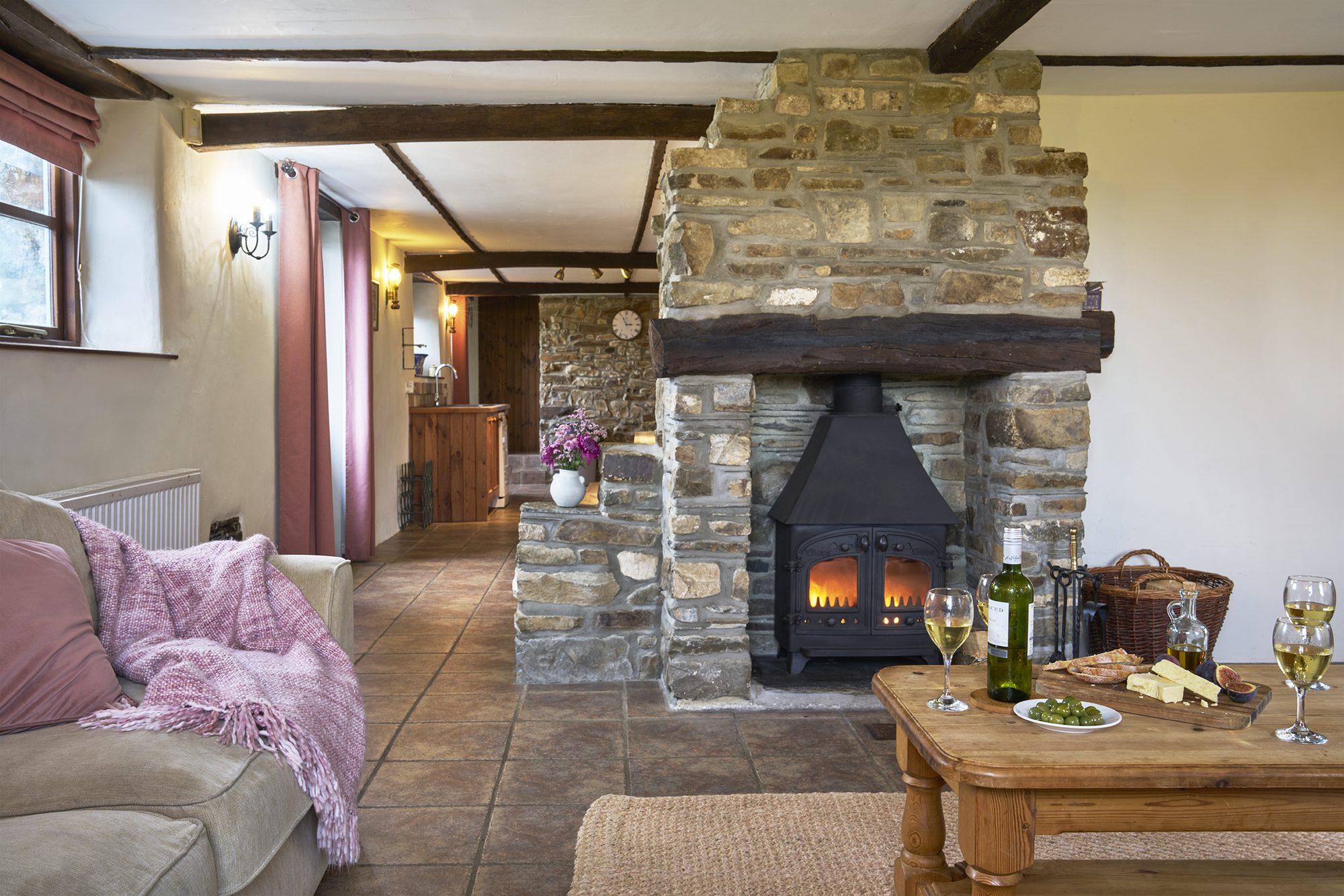 Rose Cottage lounge with the stone fireplace and wood burner lit